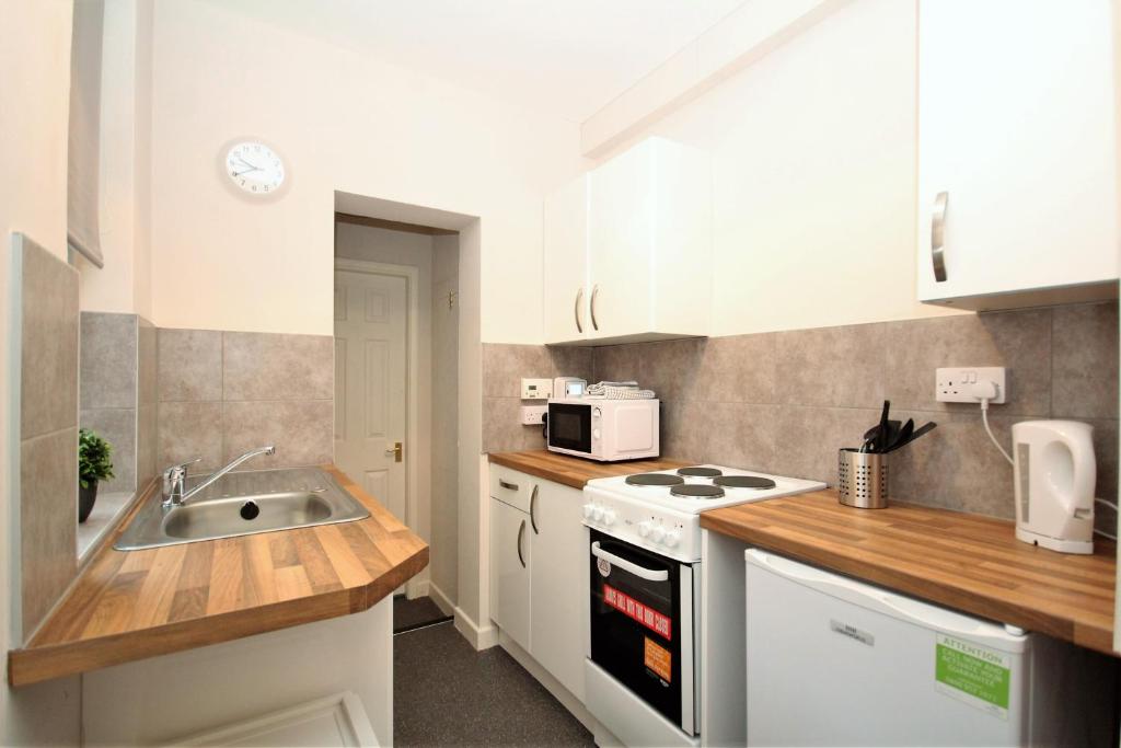 uma cozinha com um lavatório e um fogão forno superior em Maritime Apartments em Barrow in Furness