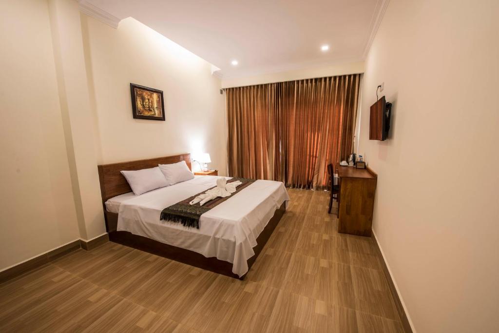 Postel nebo postele na pokoji v ubytování Phnom Penh Le Vincent Hotel
