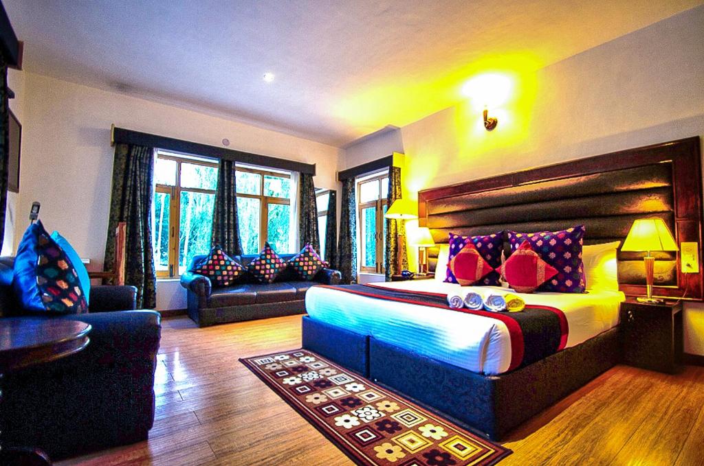 a bedroom with a large bed and a living room at Gomang Boutique Hotel in Leh