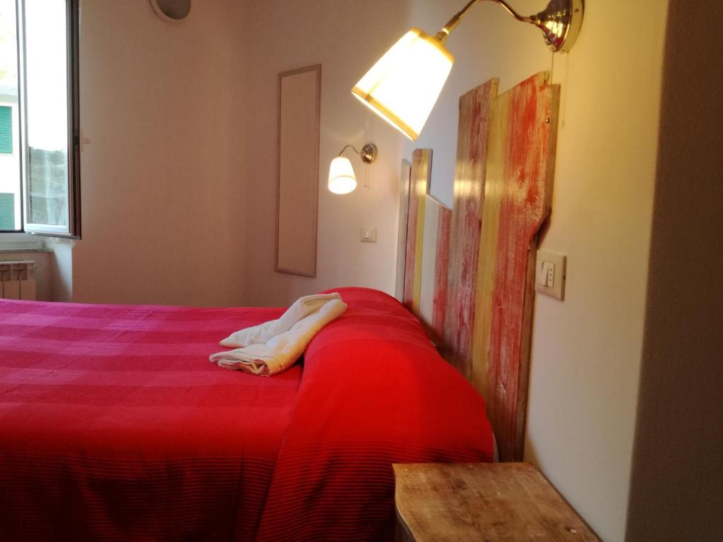 una persona sdraiata su un letto rosso in una stanza di Appartamento Via Signorini a Riomaggiore