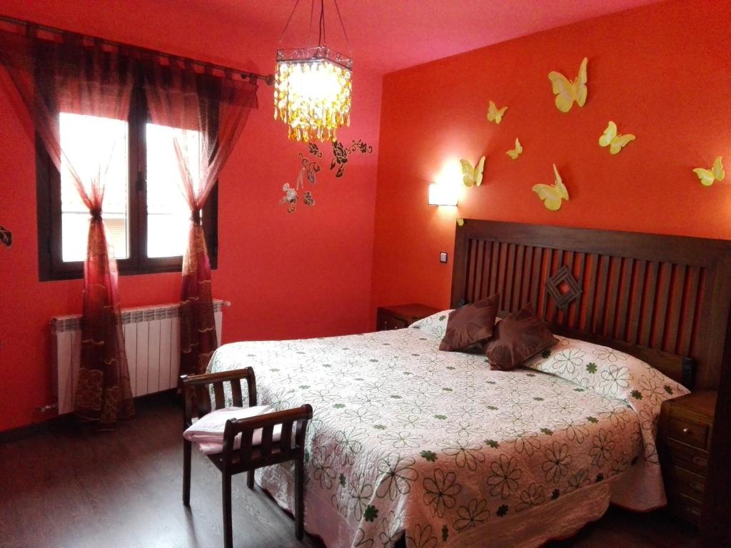 1 dormitorio con 1 cama con mariposas en la pared en Nature Love, en Casas del Abad