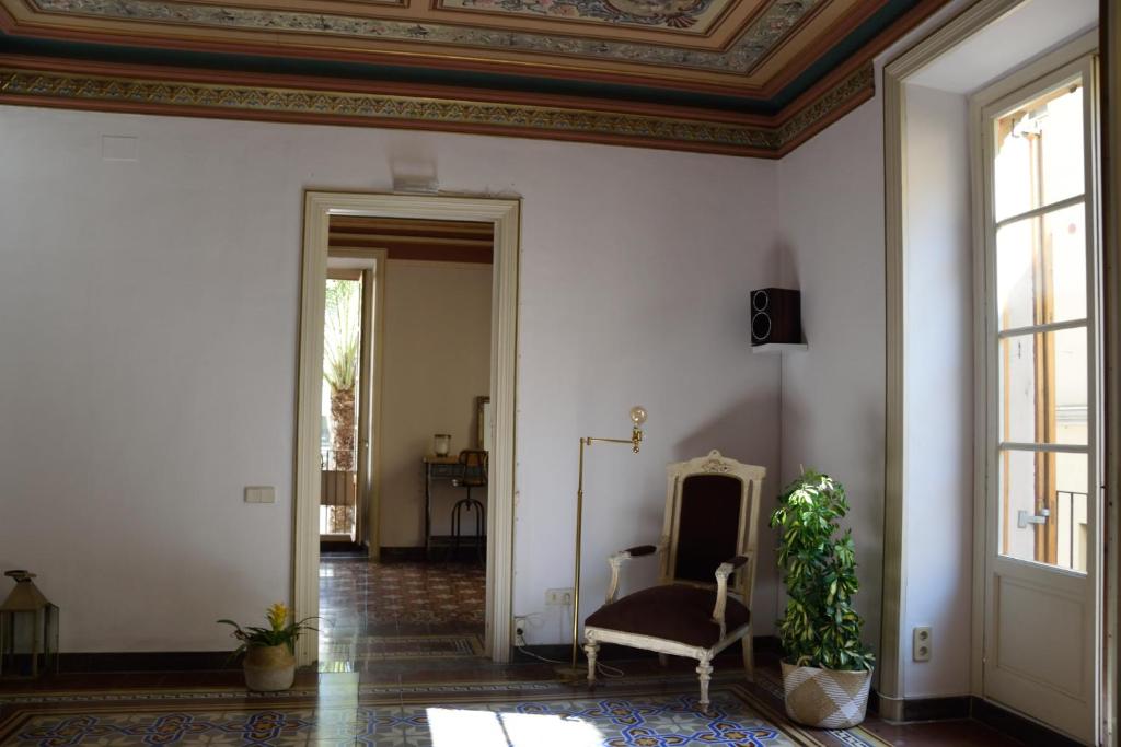 a living room with a chair and a ceiling at Piso Vilanova i la Geltrú in Vilanova i la Geltrú