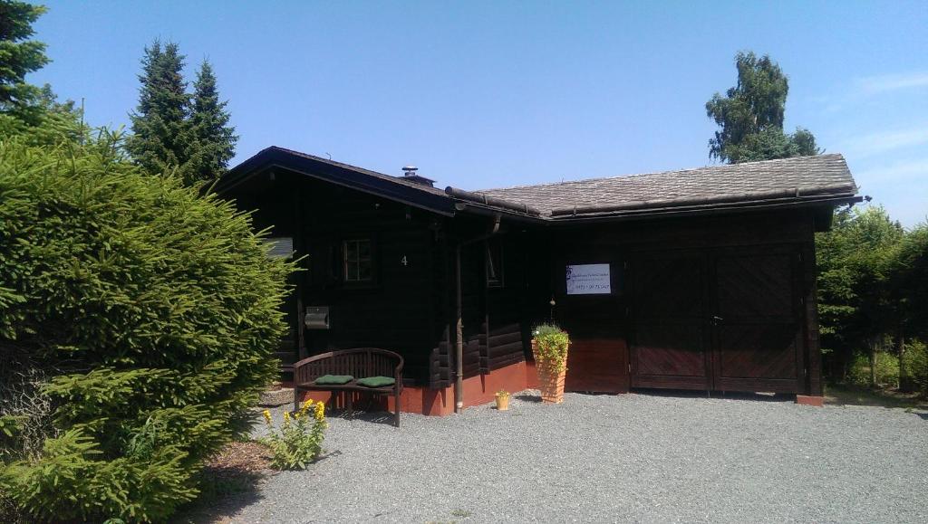 a black building with a bench in front of it at Blockhaus FerienZauber in Bromskirchen