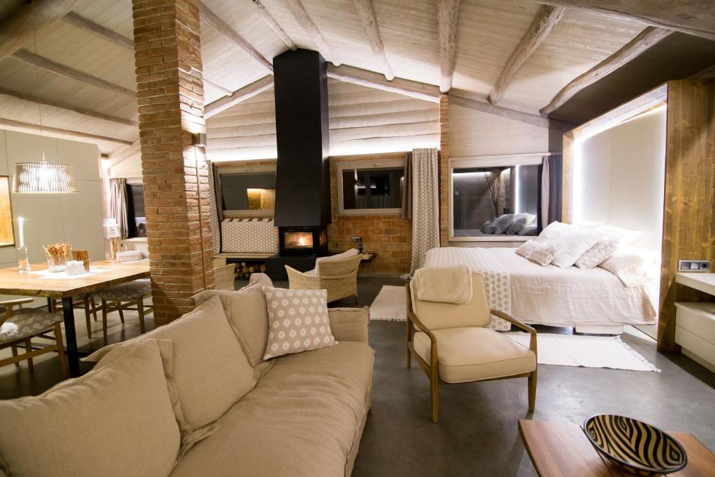 a bedroom with a bed and a couch and a table at El Porxo de la Barraca in Caserras