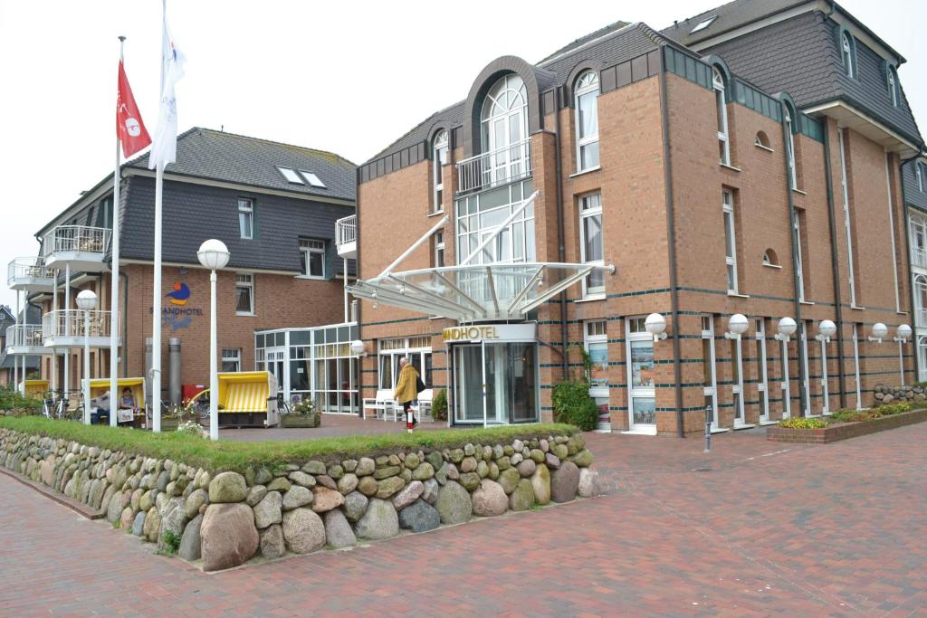 a building with a row of rocks in front of it at Strandhotel Sylt Westerland in Westerland
