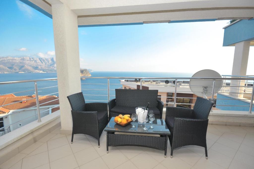 Apartments Spas في بودفا: شرفة مع طاولة وكراسي مطلة على المحيط