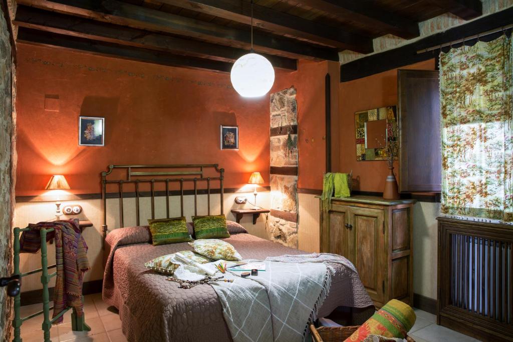 a bedroom with a bed in a room with orange walls at Casa Rural la Casa del Bosque in Navaconcejo