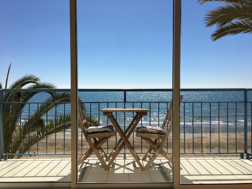 錫切斯的住宿－茵西格斯聖賽巴思提安海灘酒店，海滩阳台的一张桌子和两把椅子