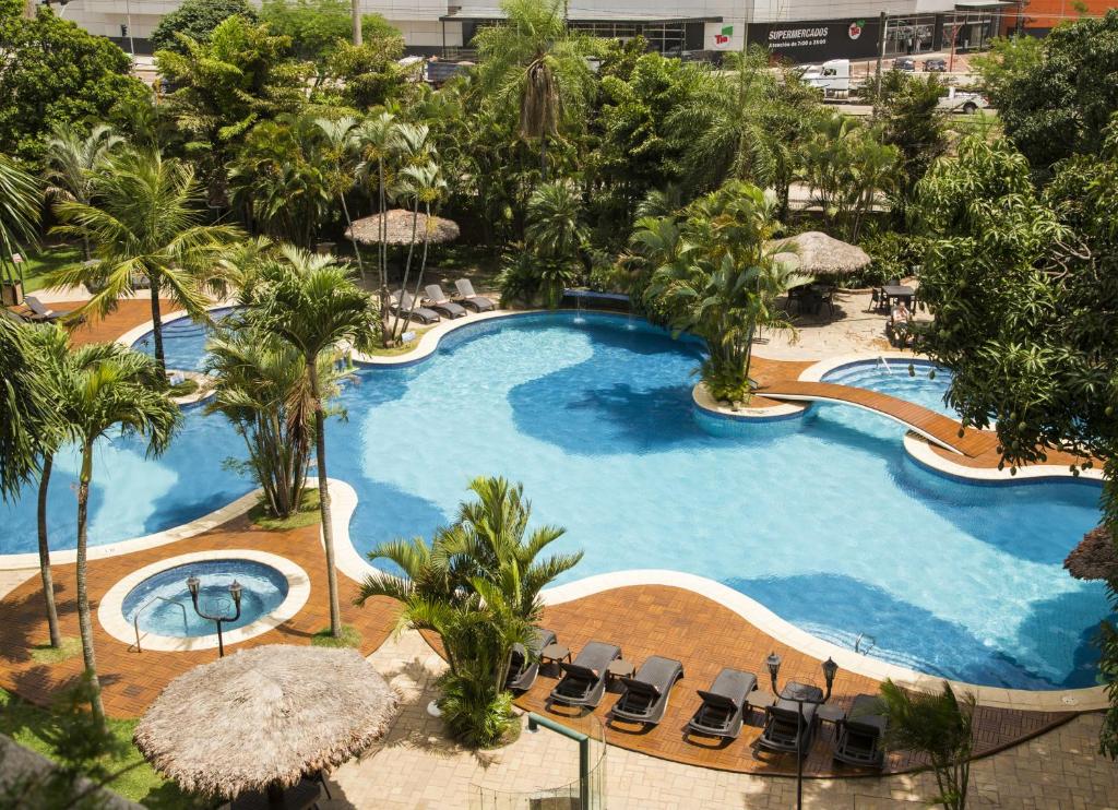 una vista aérea de una gran piscina con palmeras en Hotel Camino Real, en Santa Cruz de la Sierra