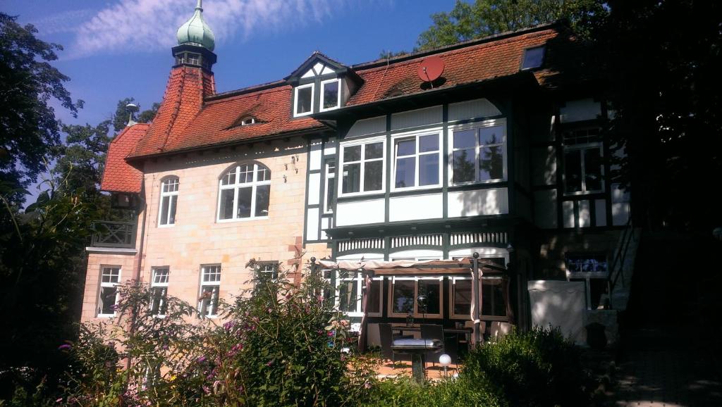 una gran casa de ladrillo con techo rojo en Ferienwohnung Schloß am Schloßberg en Bad Berka