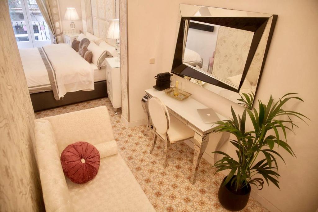 Habitación de hotel con escritorio y espejo en Hostal Casa Boutique, en Madrid
