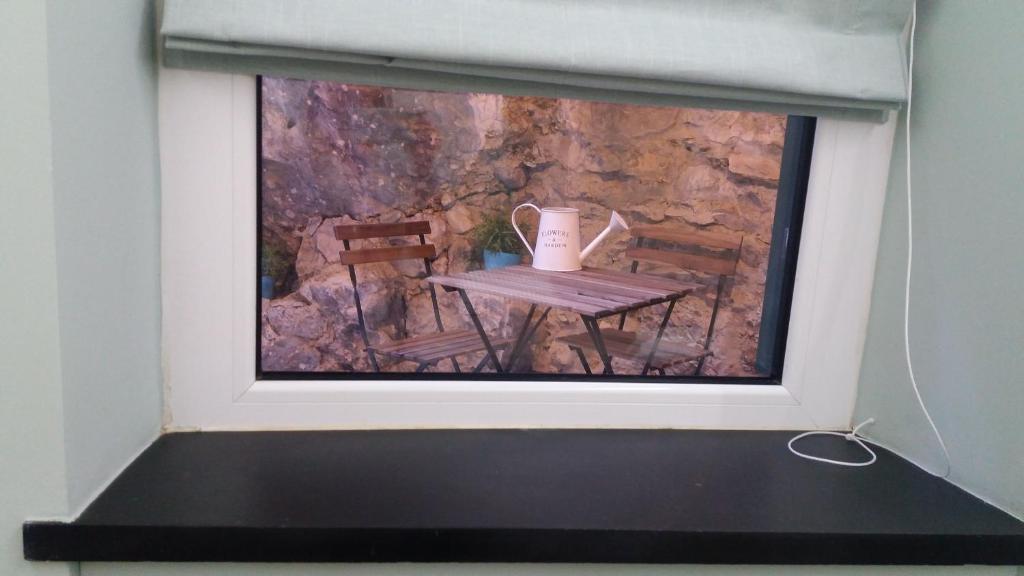 a painting of a table with a jug on a window at Clara's House in Portofino