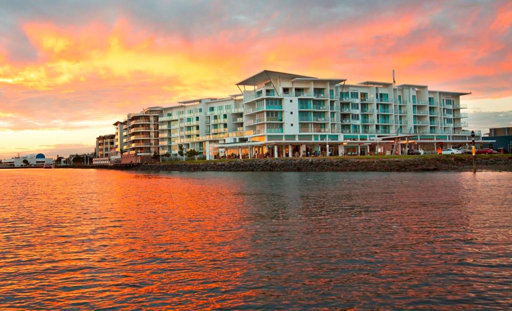 a large building on the shore of a body of water at Ramada Hotel & Suites by Wyndham Ballina Byron in Ballina