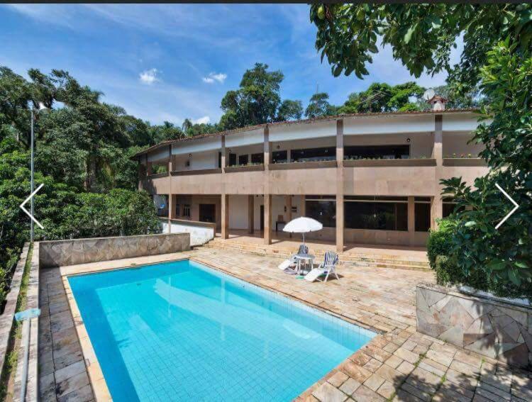 a large building with a swimming pool in front of it at Casa na Serra da Cantareira in Mairiporã