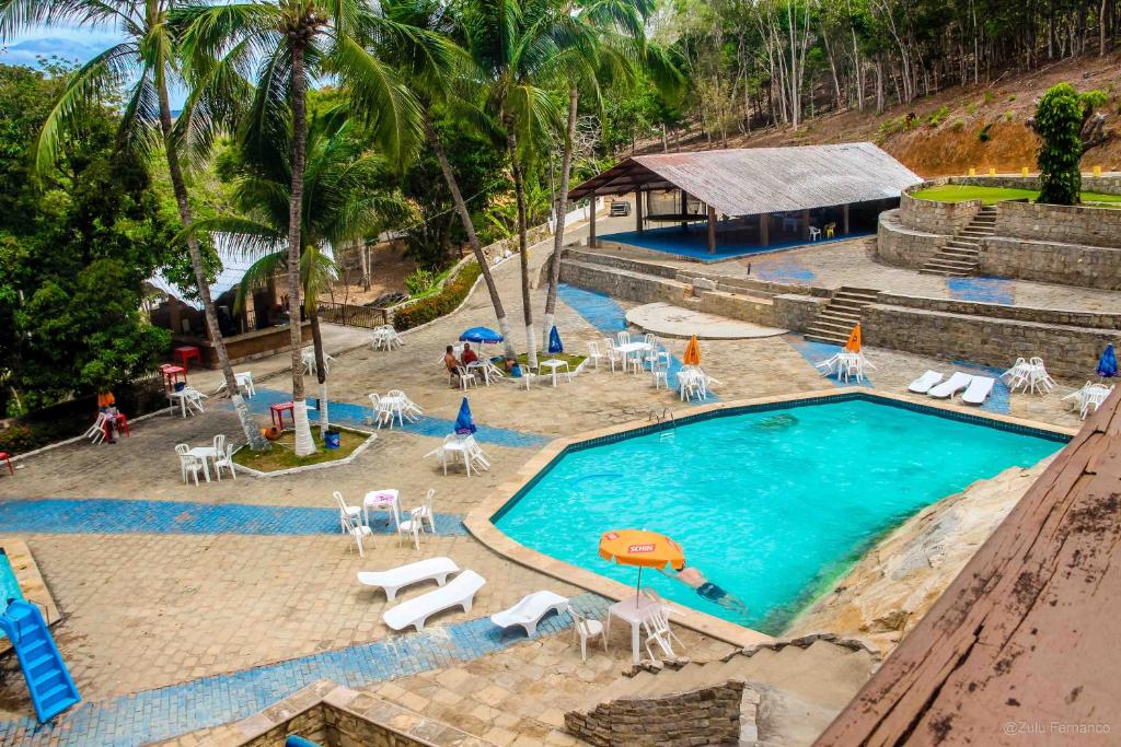 an overhead view of a swimming pool with chairs and umbrellas at Quilombo Hotel Fazenda in União dos Palmares