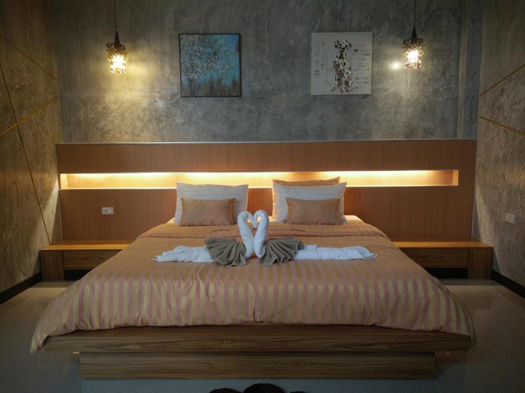 - une chambre avec un lit avec deux animaux rembourrés dans l'établissement Le Park 23 Boutique Resort, à Roi Et
