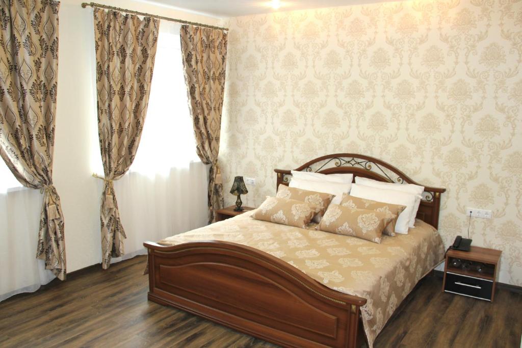 a bedroom with a bed and curtains and a window at Central Hotel in Tomsk