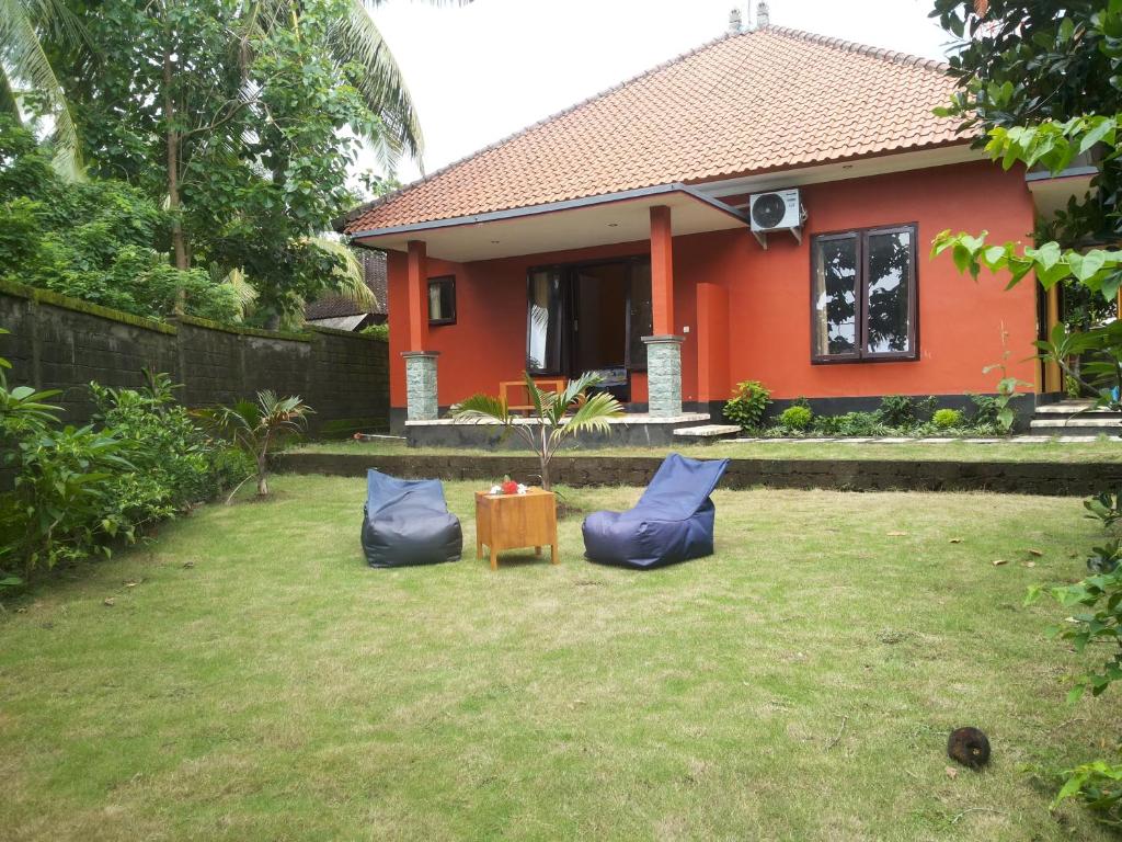 a house with two blue pillows and a table in a yard at Gede's Homestay in Tejakula