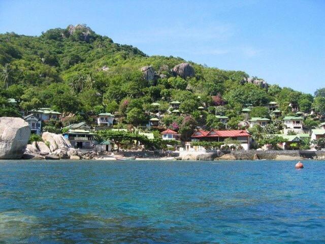 a small island with houses on a hill in the water at Family Tanotebay Resort in Ko Tao