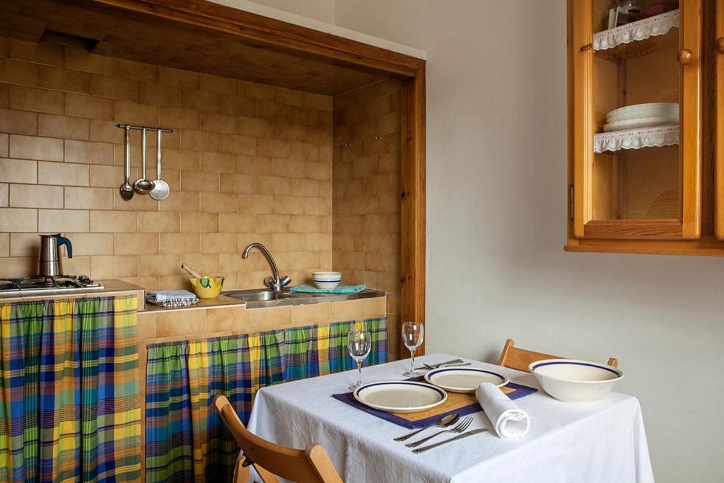 eine Küche mit einem Tisch mit Tellern und Schüsseln darauf in der Unterkunft Apartamentos Es Carnatge - Formentera Vacaciones in Playa Migjorn
