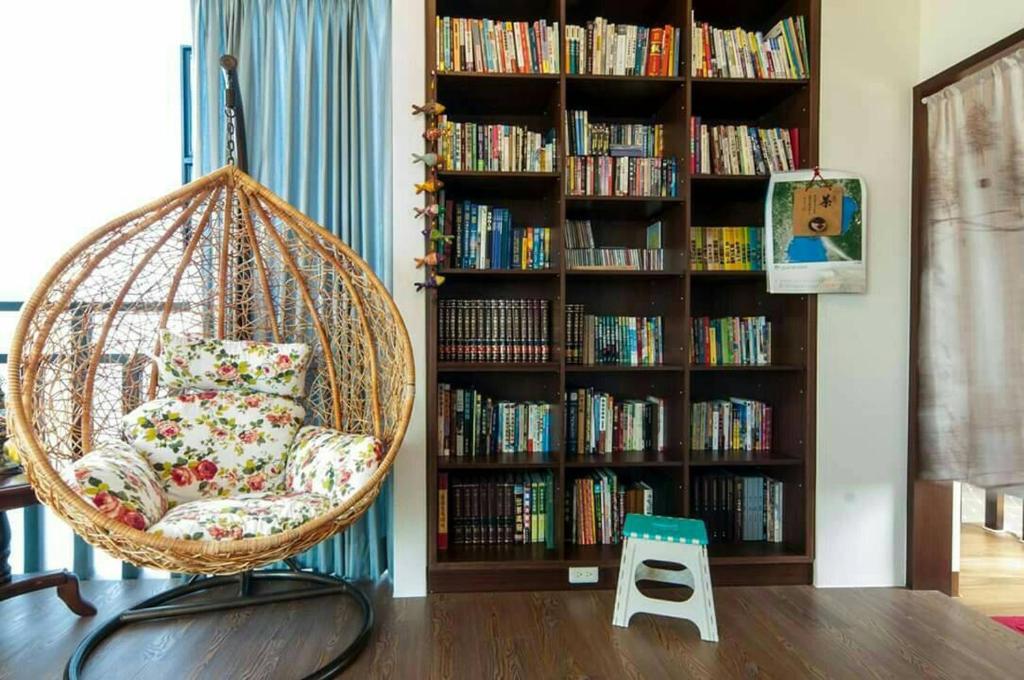 a room with a chair and a book shelf with books at Longman Villa in Huxi