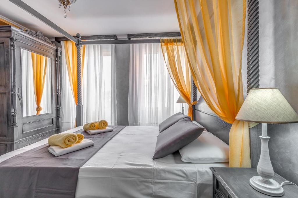 a bedroom with a large bed with yellow curtains at Eos Aurora Suite in Corfu Town