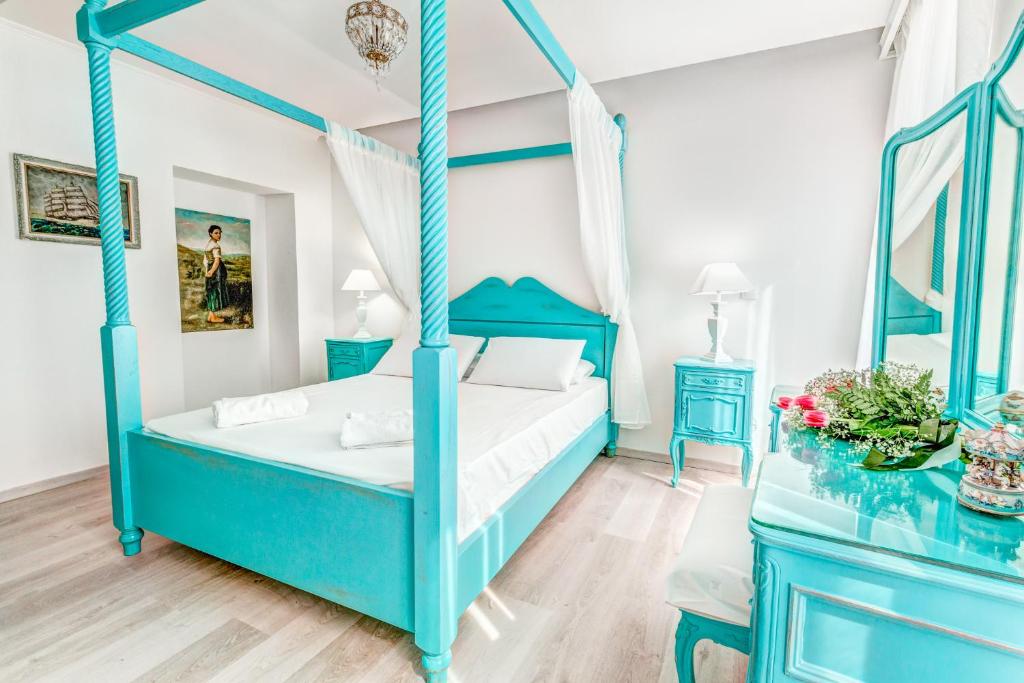 コルフ・タウンにあるBelone Suiteのベッドルーム(青いベッド1台、鏡付)