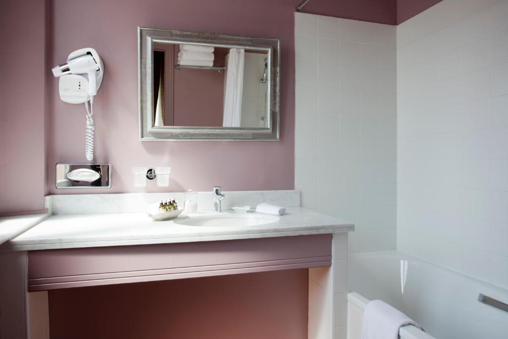a bathroom with a sink and a mirror at Le Cavendish in Cannes