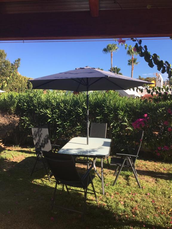 a table and two chairs with an umbrella at Los tunos campo internacional in Maspalomas