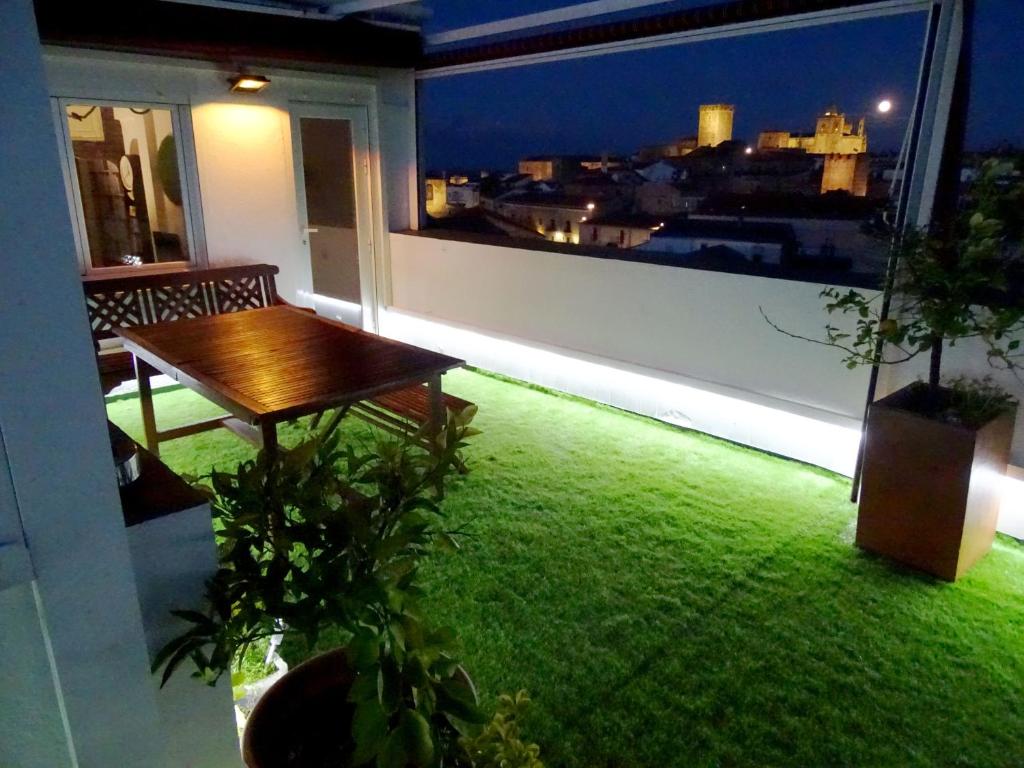 een balkon met een tafel en uitzicht op de stad bij Atico77 in Cáceres