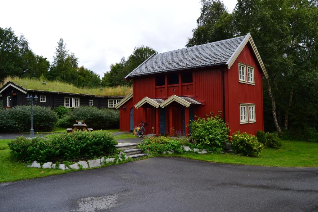 eine rote Scheune mit schwarzem Dach in der Unterkunft Vekve Hyttetun in Oppdal