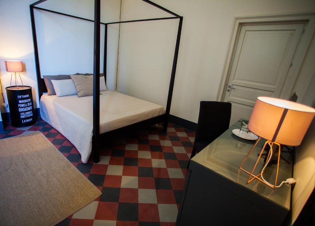 a bedroom with a bed and a table with a lamp at Le stanze del Capostazione in Bagheria
