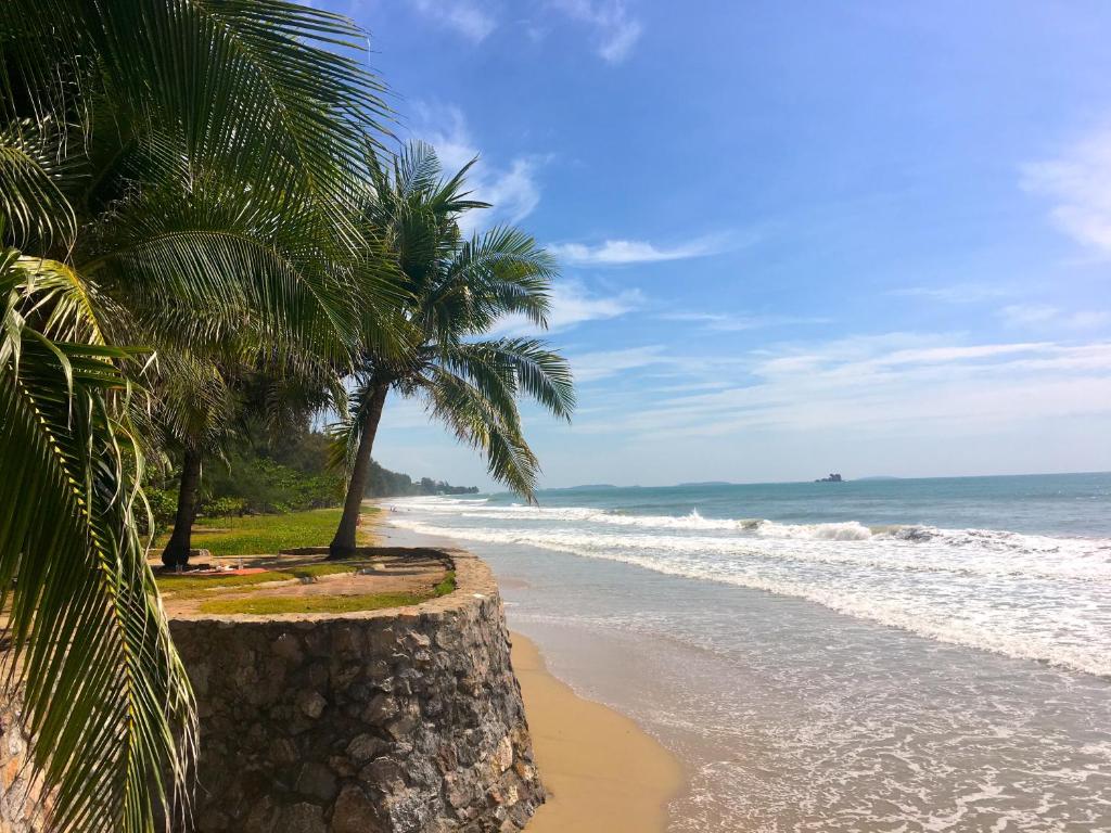 a beach with palm trees and the ocean at AG Property in Mae Pim