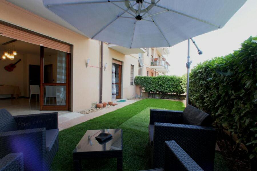 une terrasse avec une table et un parasol dans l'établissement B&B Holidays Artisti, à Peschiera del Garda