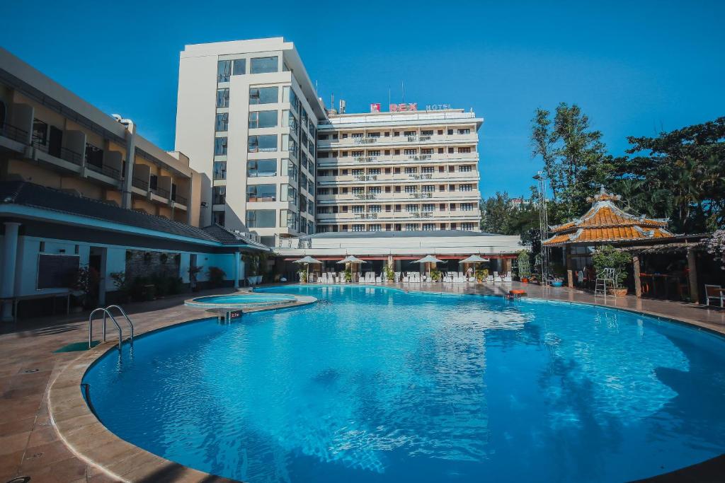 a large swimming pool in front of a building at Rex Hotel in Vung Tau