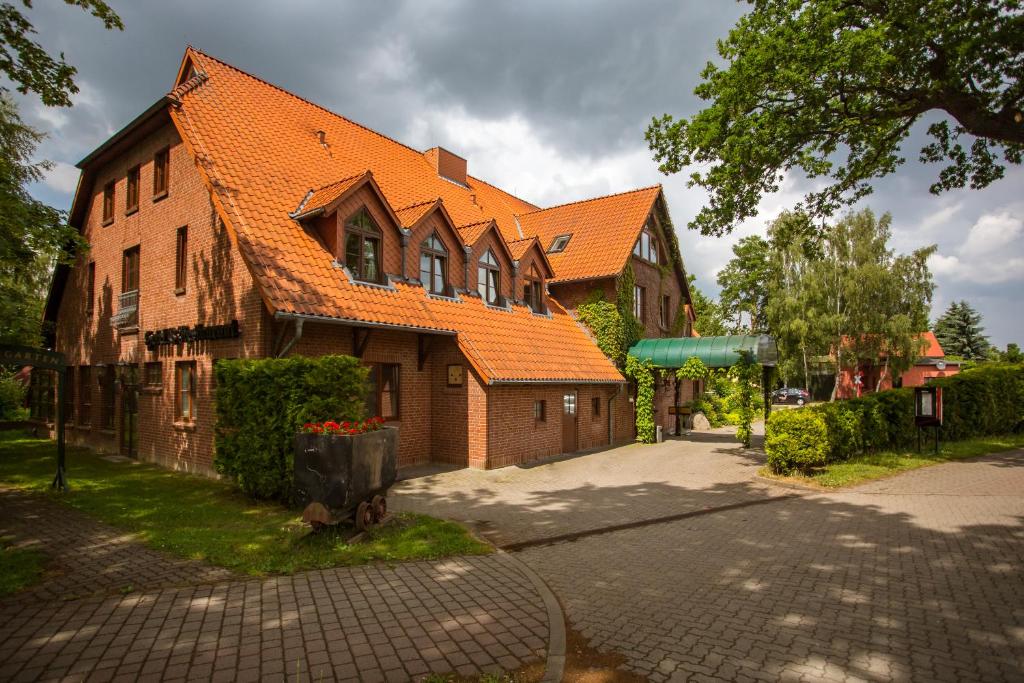 ein großes Backsteingebäude mit orangefarbenem Dach in der Unterkunft Hotel Stettiner Hof in Greifswald