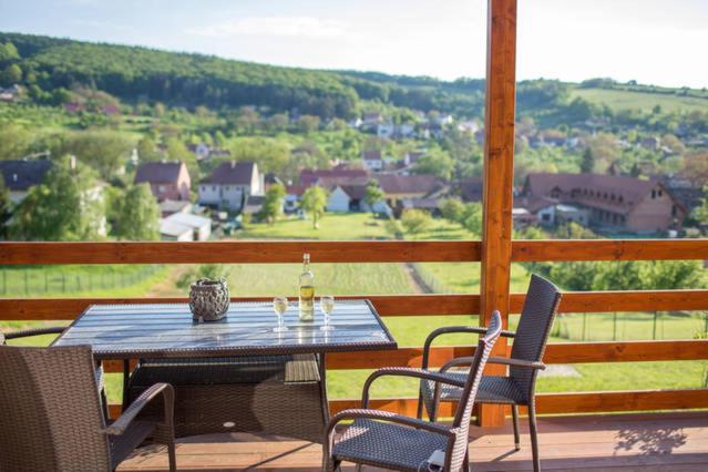 - une table et des chaises sur une terrasse couverte offrant une vue sur la vallée dans l'établissement Chalupa U Vinaře, à Radějov