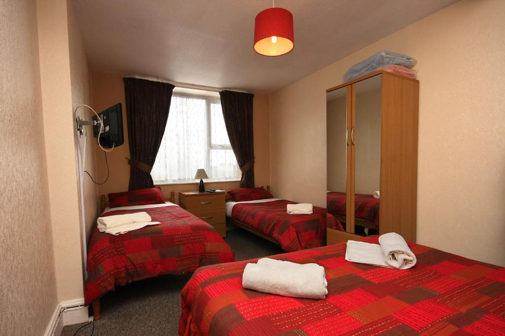 a hotel room with two beds and a mirror at Boltonia in Blackpool