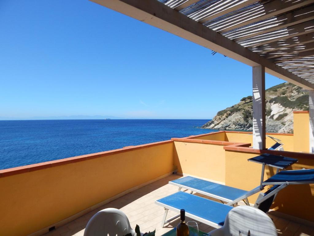 a balcony with chairs and a view of the ocean at Appartamenti - Villa Mare in Pomonte