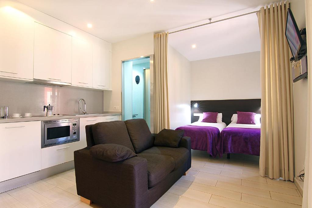 een keuken en een woonkamer met een bank en een bed bij ClassBedroom Barcelona Beach Apartments in Barcelona