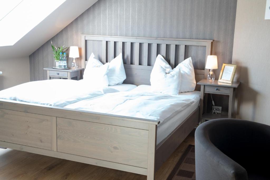 1 dormitorio con 1 cama blanca grande con almohadas blancas en Weddeler Hof, en Cremlingen