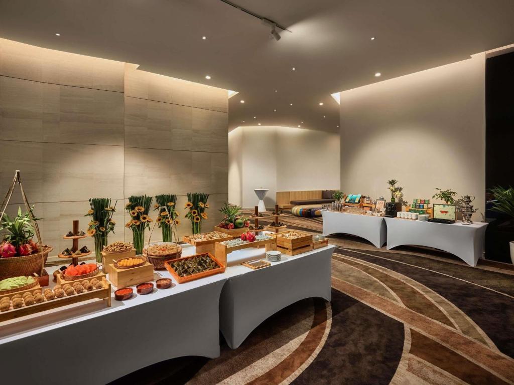 A warmly lit buffet area with breads, fruit, and prepared breakfast foods.