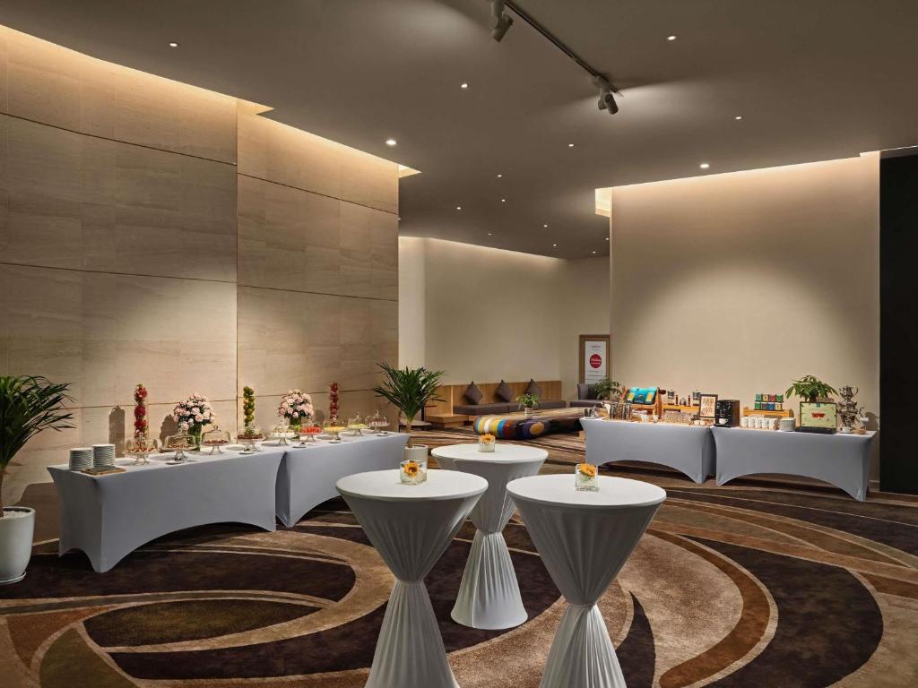 A softly lit event foyer set with cocktail tables, buffet tables and floral displays.