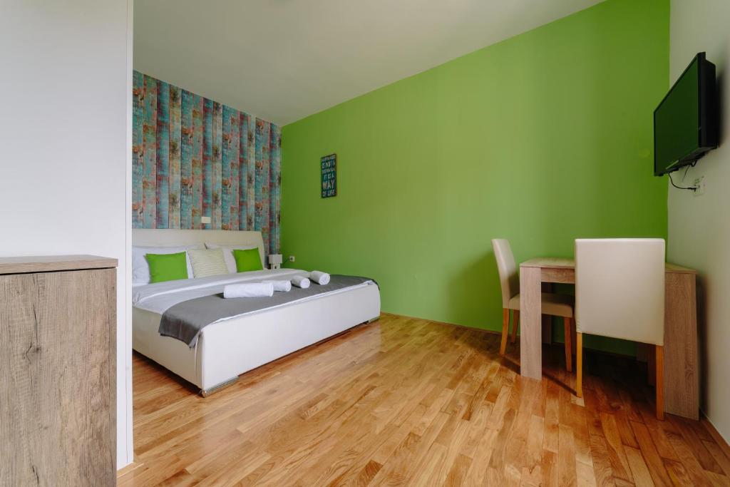 1 dormitorio con paredes verdes, 1 cama y 1 mesa en Piranika, en Piran