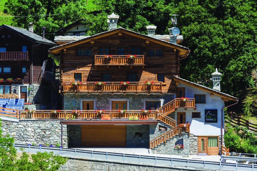 Cette grande maison en bois possède un balcon. dans l'établissement 4478 Mountain Lodge, à Valtournenche