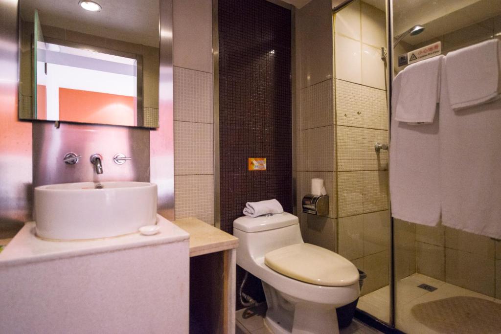 a bathroom with a toilet and a sink and a shower at Motel Zhangjiagang Jingang Town Middle Changjiang Road Government in Zhangjiagang