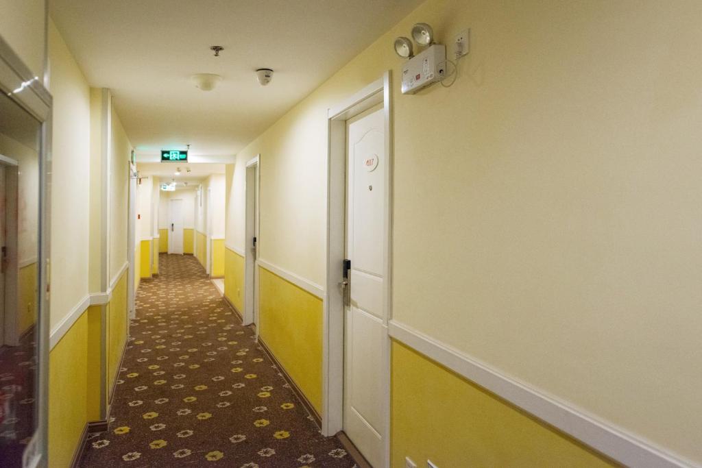 a corridor of a hospital hallway with yellow and white walls at Home Inn Dalian Xinghai Bay Wuyi Road Nansha Street in Dalian