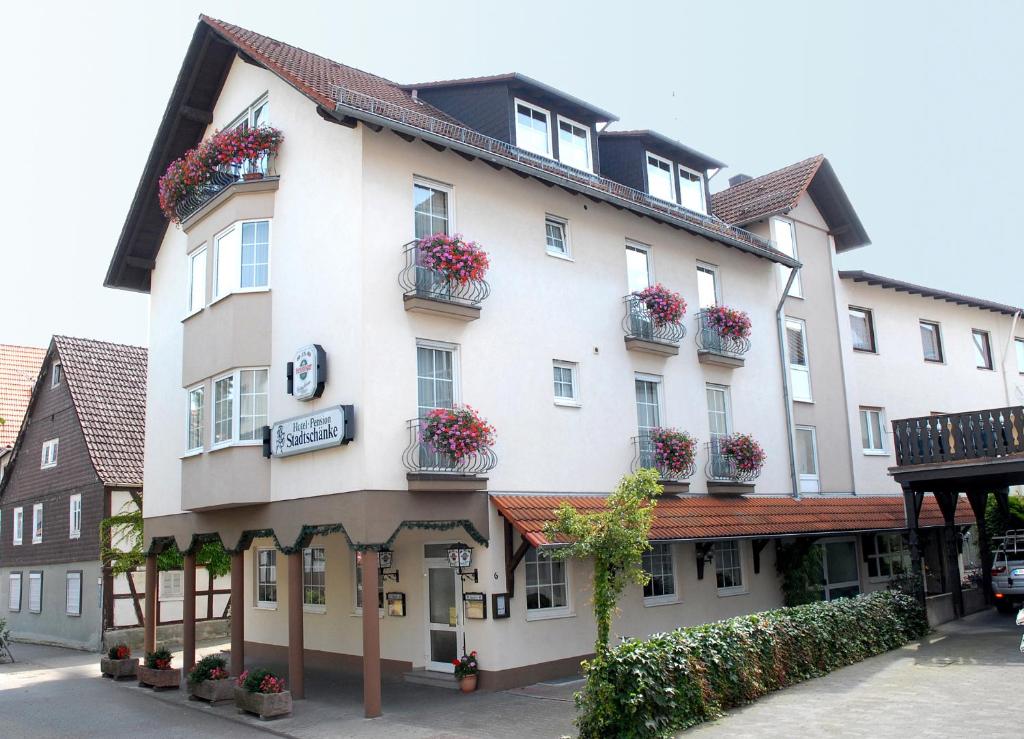 un gran edificio blanco con cajas de flores. en Hotel Stadtschänke, en Bad König