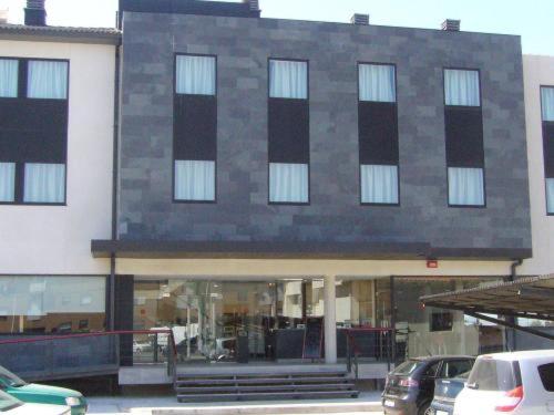 a building with cars parked in front of it at Hotel Alfinden in Puebla de Alfindén