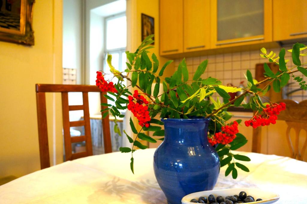 a blue vase with red flowers on a table at 90 sq.m. apartment in centre of Vilnius in Vilnius